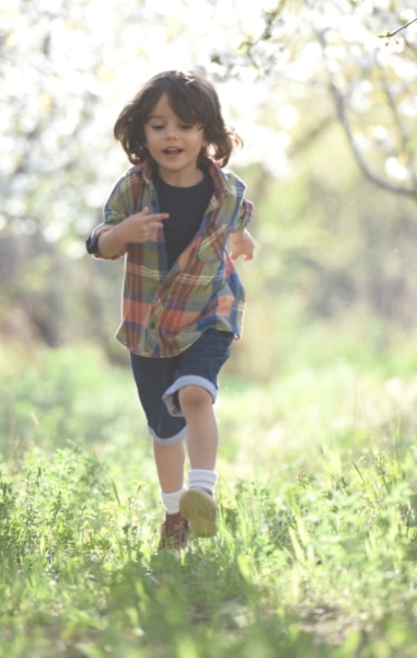 Child running through the forest having a great time connecting with nature